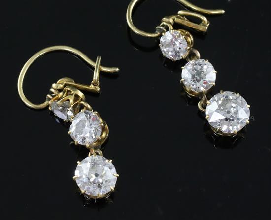 A pair of gold and graduated three stone diamond set drop earrings, 22mm.